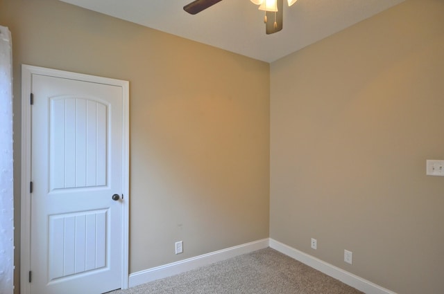 carpeted spare room with ceiling fan