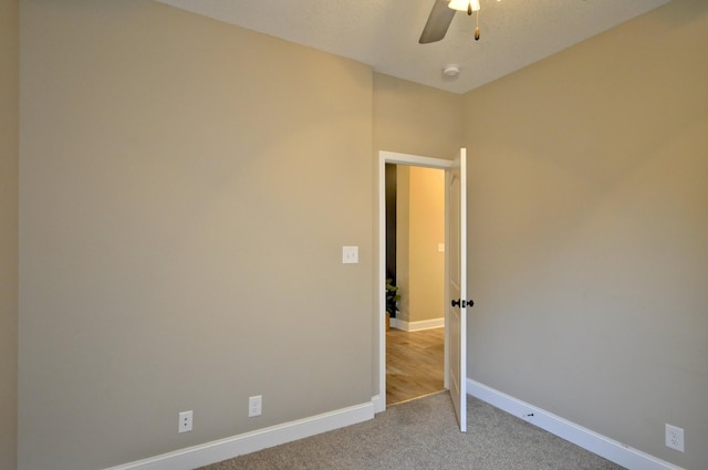 carpeted spare room featuring ceiling fan