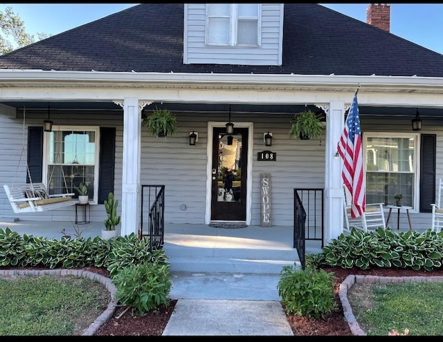 view of exterior entry with covered porch