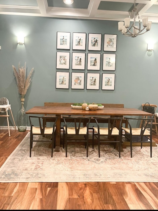 dining space featuring coffered ceiling, hardwood / wood-style floors, breakfast area, and an inviting chandelier