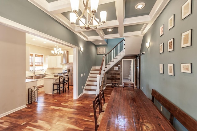 dining space with stairway, an inviting chandelier, wood finished floors, coffered ceiling, and beamed ceiling