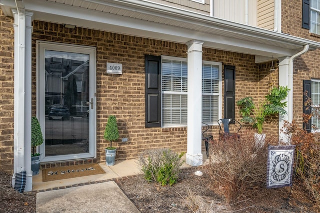 view of exterior entry featuring brick siding