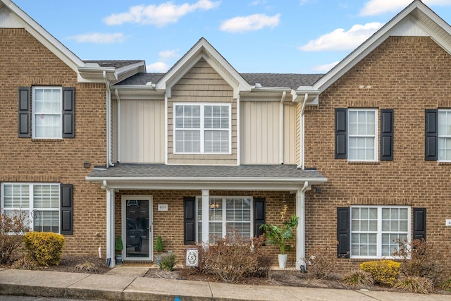 townhome / multi-family property with brick siding and a shingled roof