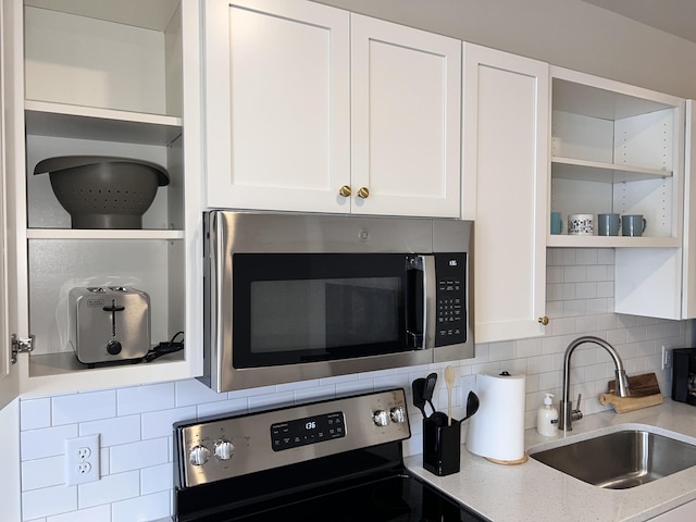 kitchen with sink, stainless steel appliances, and white cabinetry