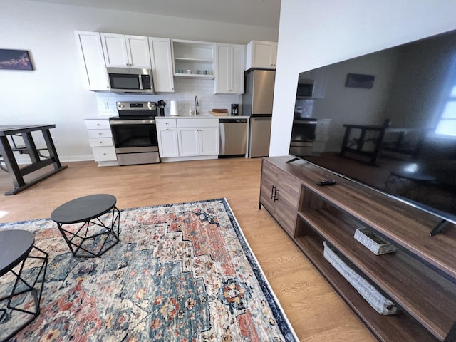 kitchen with sink, appliances with stainless steel finishes, white cabinets, and tasteful backsplash