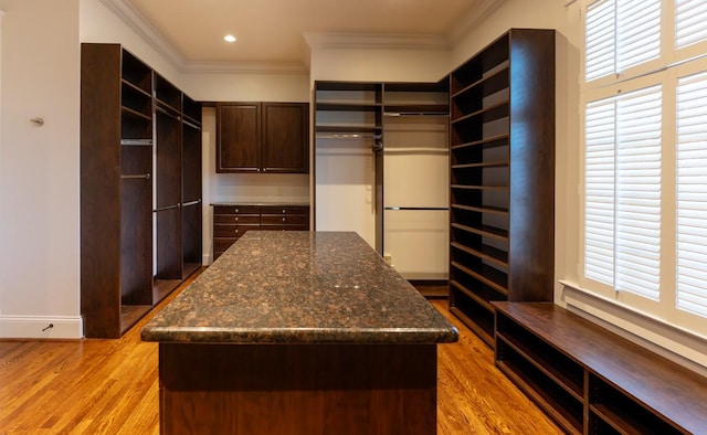 walk in closet with light hardwood / wood-style flooring