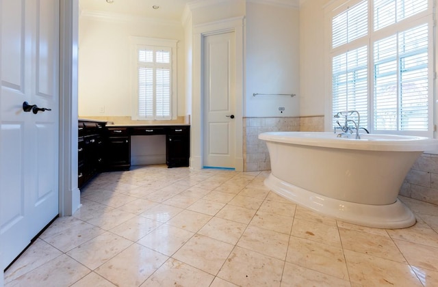 bathroom with tile walls, crown molding, a bathtub, and tile patterned floors