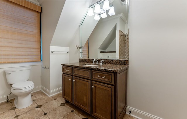 bathroom featuring vanity, toilet, and lofted ceiling