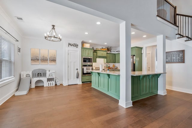 kitchen featuring green cabinets, ornamental molding, stainless steel appliances, and dark wood finished floors