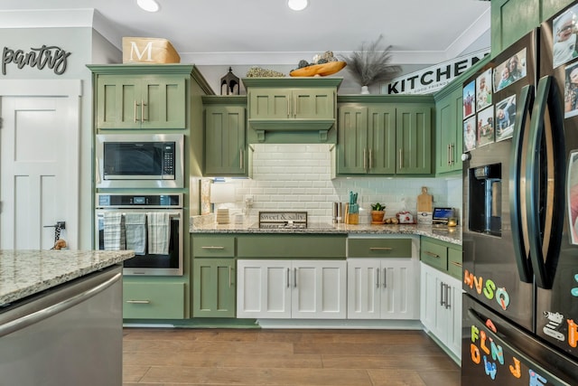 kitchen featuring dark wood-style flooring, decorative backsplash, green cabinets, light stone countertops, and black appliances