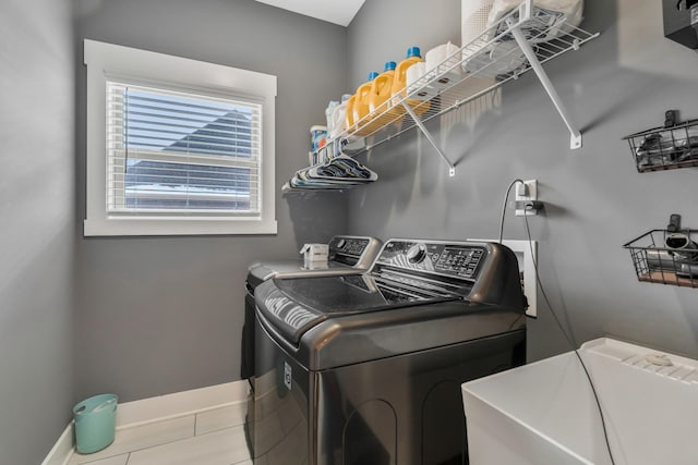 laundry area featuring laundry area, a sink, baseboards, and separate washer and dryer