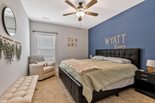 bedroom with ceiling fan, visible vents, and light colored carpet