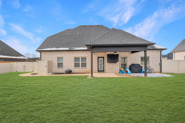 rear view of property with a lawn, a patio area, a fenced backyard, and a gate