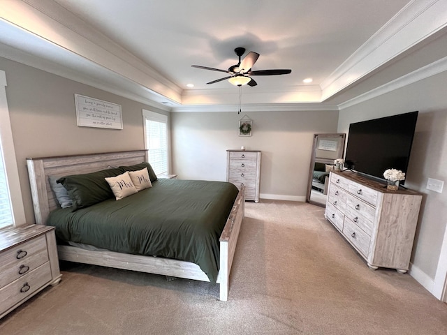 bedroom with baseboards, a tray ceiling, light colored carpet, and ornamental molding