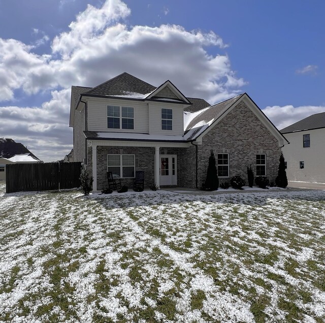 view of front of property featuring brick siding and fence