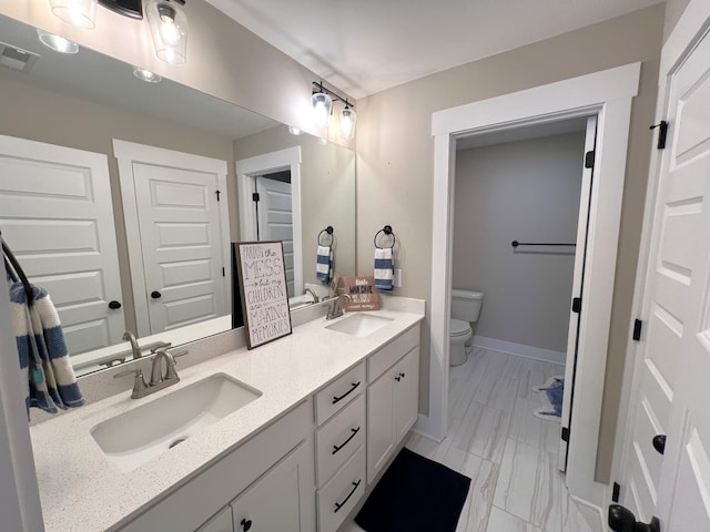 full bathroom featuring a sink, toilet, and double vanity