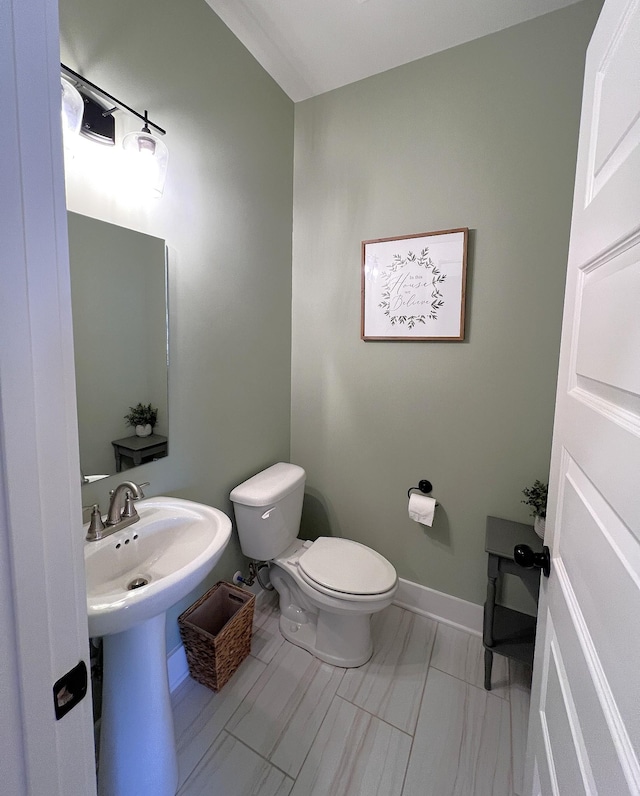 bathroom featuring toilet and baseboards