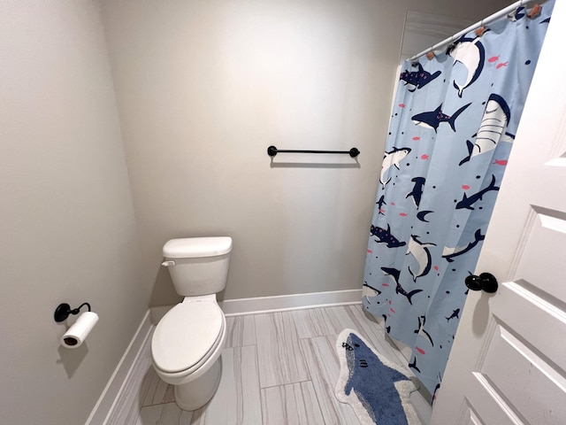 full bath with a shower with curtain, toilet, and baseboards