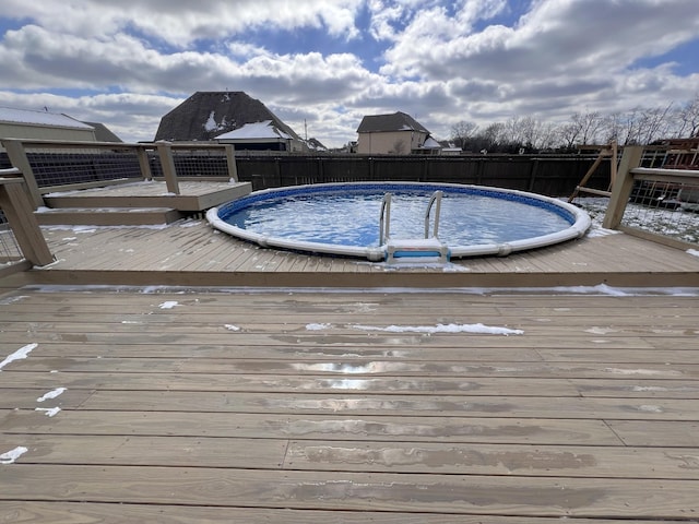 view of swimming pool with a deck, fence, and a fenced in pool