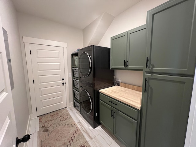 clothes washing area featuring cabinet space and stacked washing maching and dryer