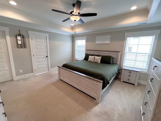 bedroom featuring baseboards, a raised ceiling, visible vents, and light colored carpet