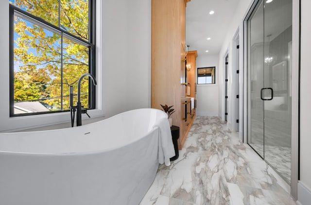 bathroom with separate shower and tub, sink, and a healthy amount of sunlight