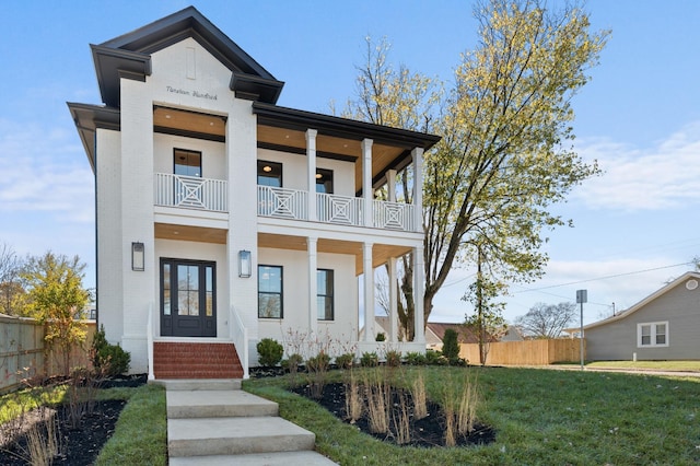 view of front of property with a balcony and a front lawn