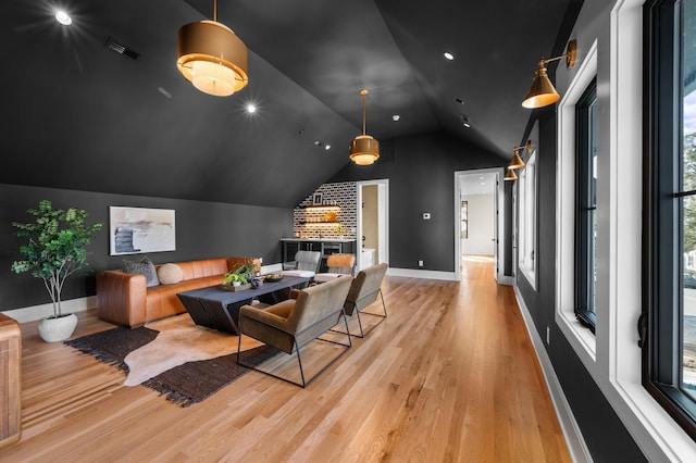 living room featuring lofted ceiling and light hardwood / wood-style flooring