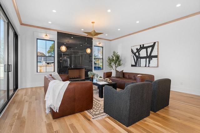 living room featuring light hardwood / wood-style floors, plenty of natural light, and crown molding