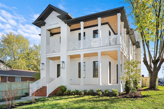 modern home featuring a balcony and a front lawn