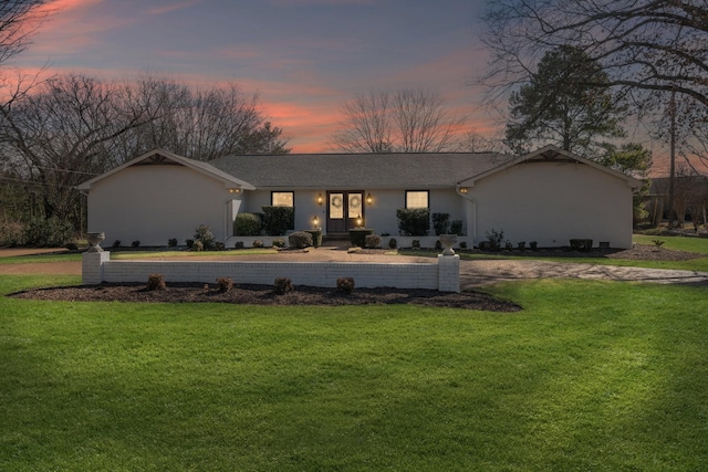 ranch-style home with a lawn