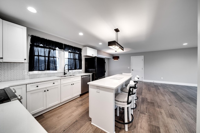 kitchen featuring a center island, white cabinetry, sink, and decorative light fixtures