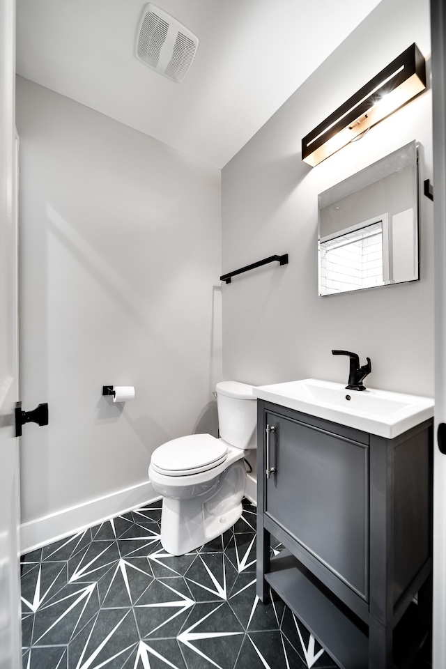 bathroom with toilet, tile patterned flooring, and vanity