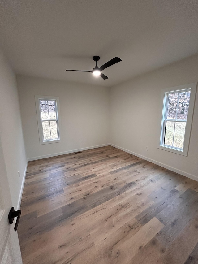 unfurnished room with hardwood / wood-style flooring and ceiling fan