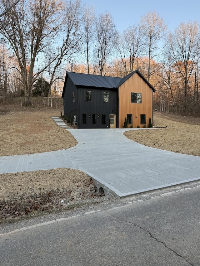 view of front facade with driveway and metal roof
