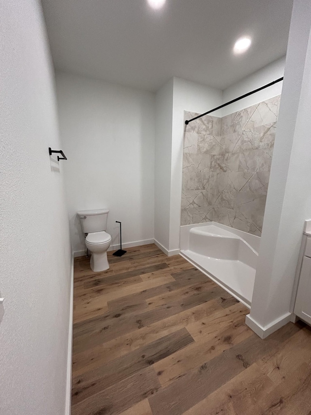 full bathroom featuring toilet, vanity, tiled shower / bath combo, and wood-type flooring