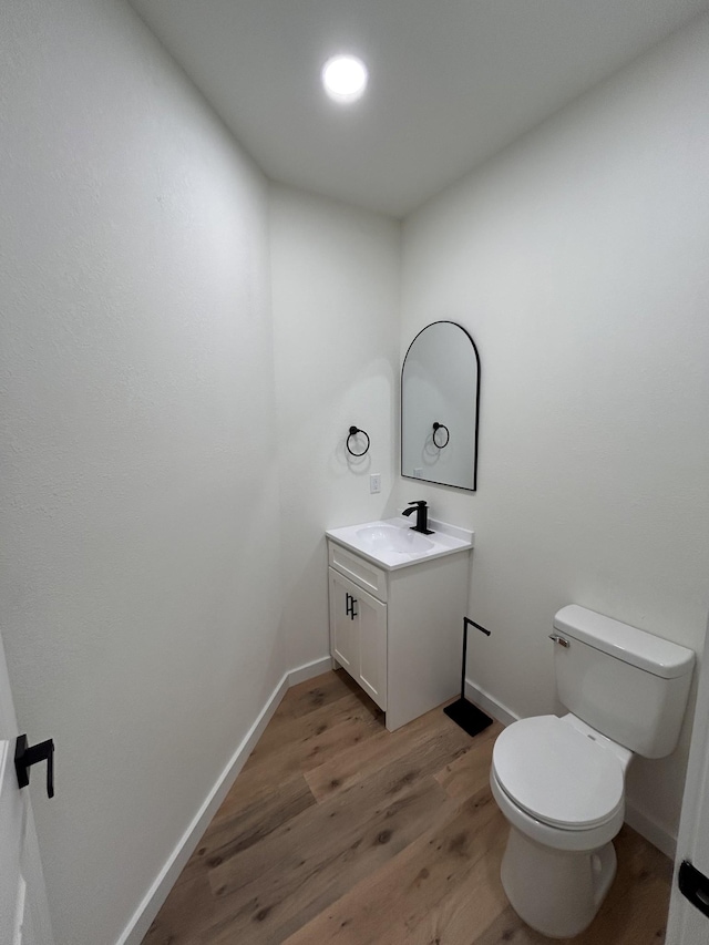 bathroom featuring hardwood / wood-style flooring, vanity, and toilet