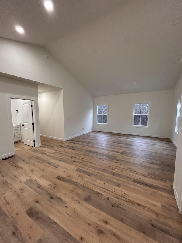 interior space with high vaulted ceiling and wood-type flooring