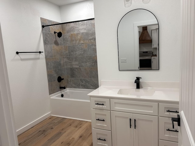 bathroom featuring tiled shower / bath combo, vanity, and wood-type flooring