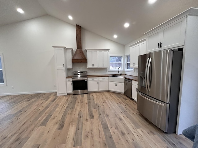 kitchen with white cabinetry, stainless steel appliances, custom exhaust hood, and sink