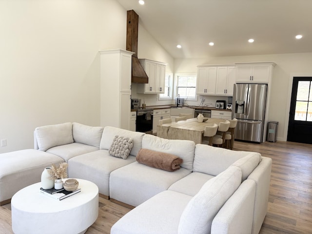 living room featuring light wood-style flooring, recessed lighting, and lofted ceiling