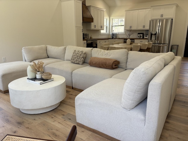 living room featuring light wood-style flooring and lofted ceiling