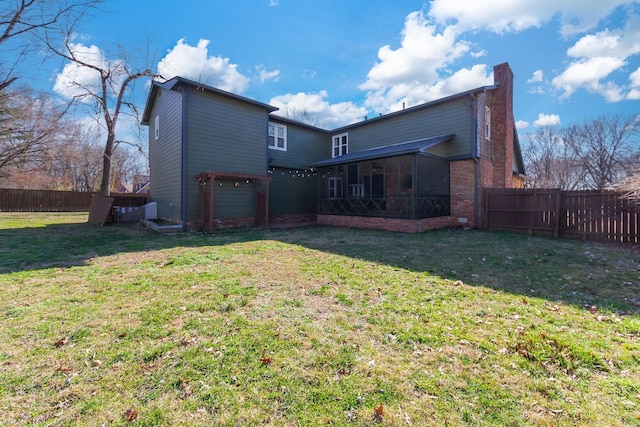 back of house with a yard and a sunroom