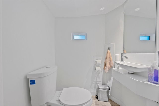 bathroom with toilet and hardwood / wood-style floors