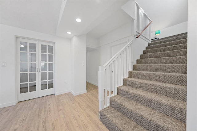 stairway featuring french doors and hardwood / wood-style floors