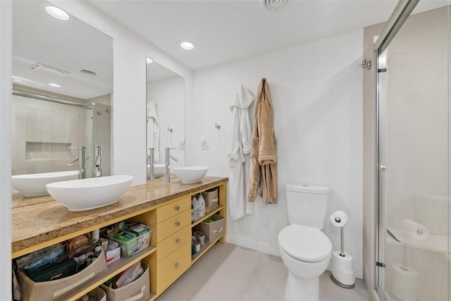 bathroom with tile patterned flooring, an enclosed shower, vanity, and toilet