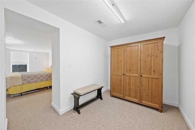 carpeted bedroom featuring a textured ceiling