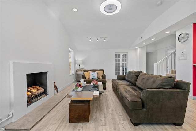 living room with light hardwood / wood-style floors and vaulted ceiling