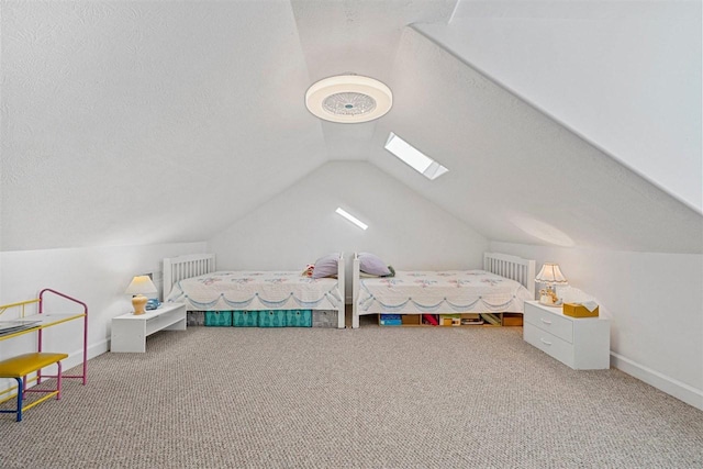 bedroom featuring vaulted ceiling with skylight, carpet, and a textured ceiling