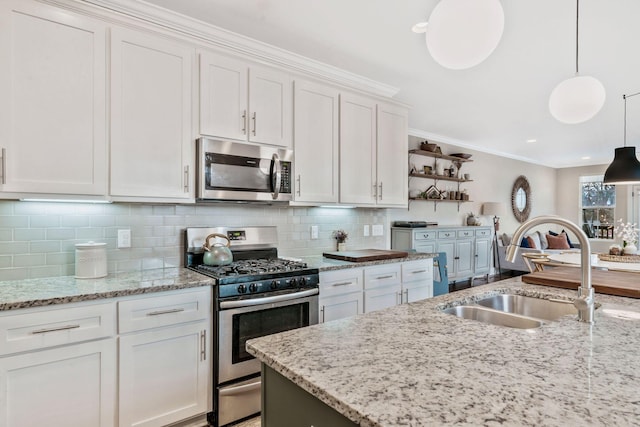 kitchen featuring appliances with stainless steel finishes, white cabinets, and decorative light fixtures